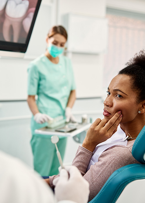 Dental patient, dentist and dental assistant discussing treatment options in the clinic
