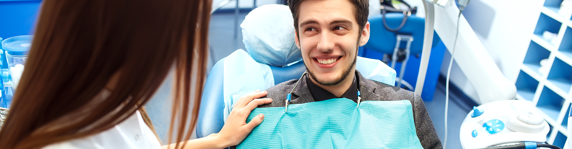 dentist resting hands on smiling patient's arm