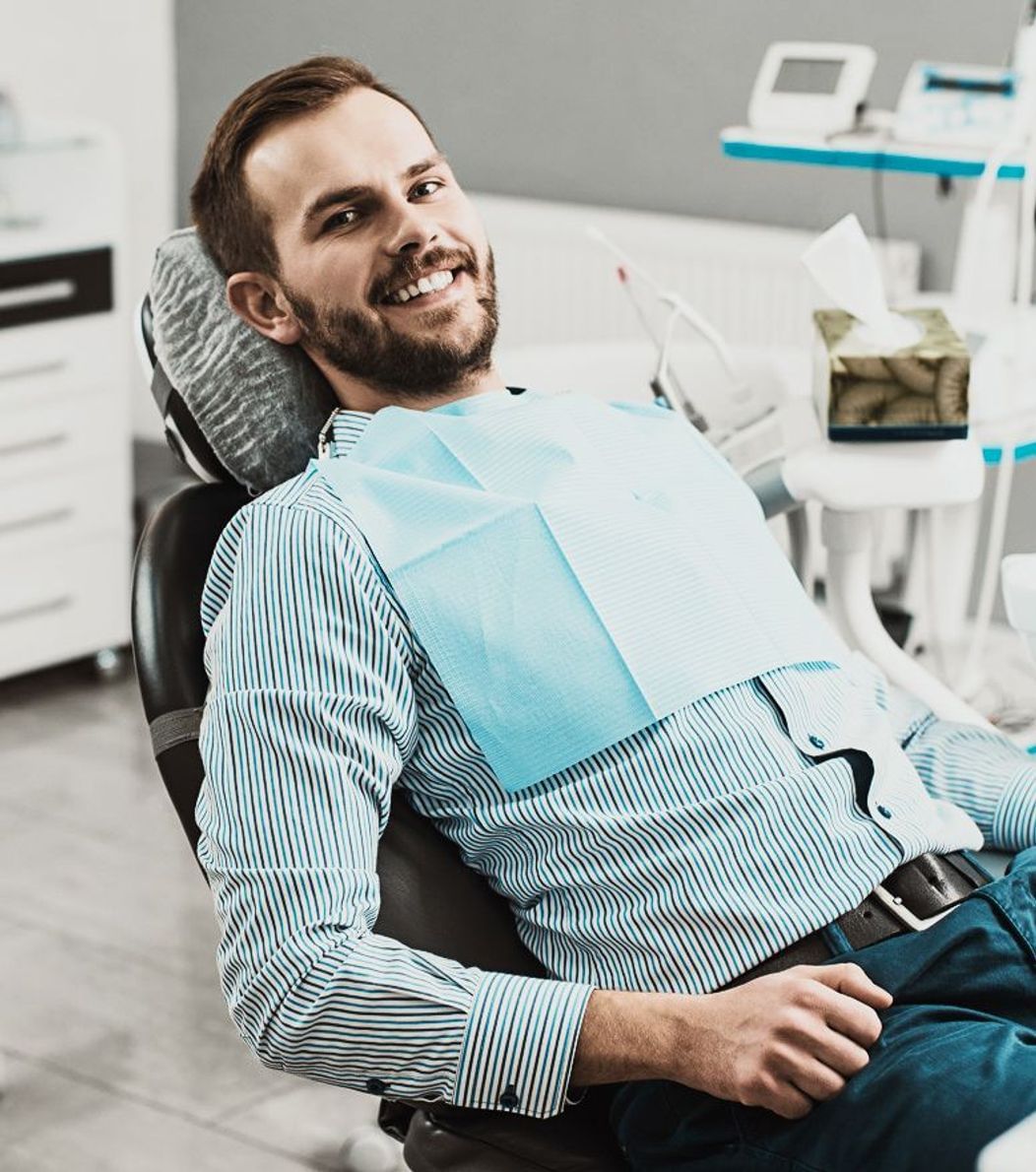 An image of a smiling man on the dental chair 