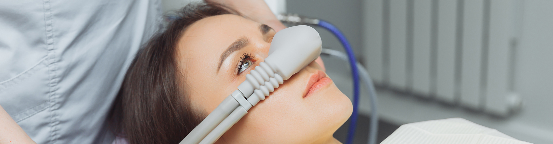dentist putting a breathing mask over patient's nose