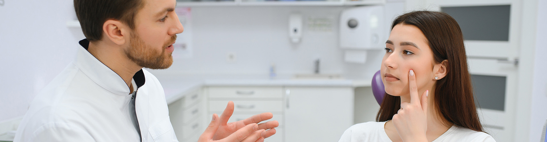 male dentist talking to female patient