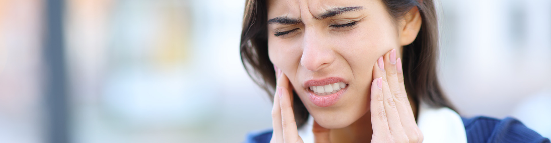 A woman showing discomfort from a toothache.